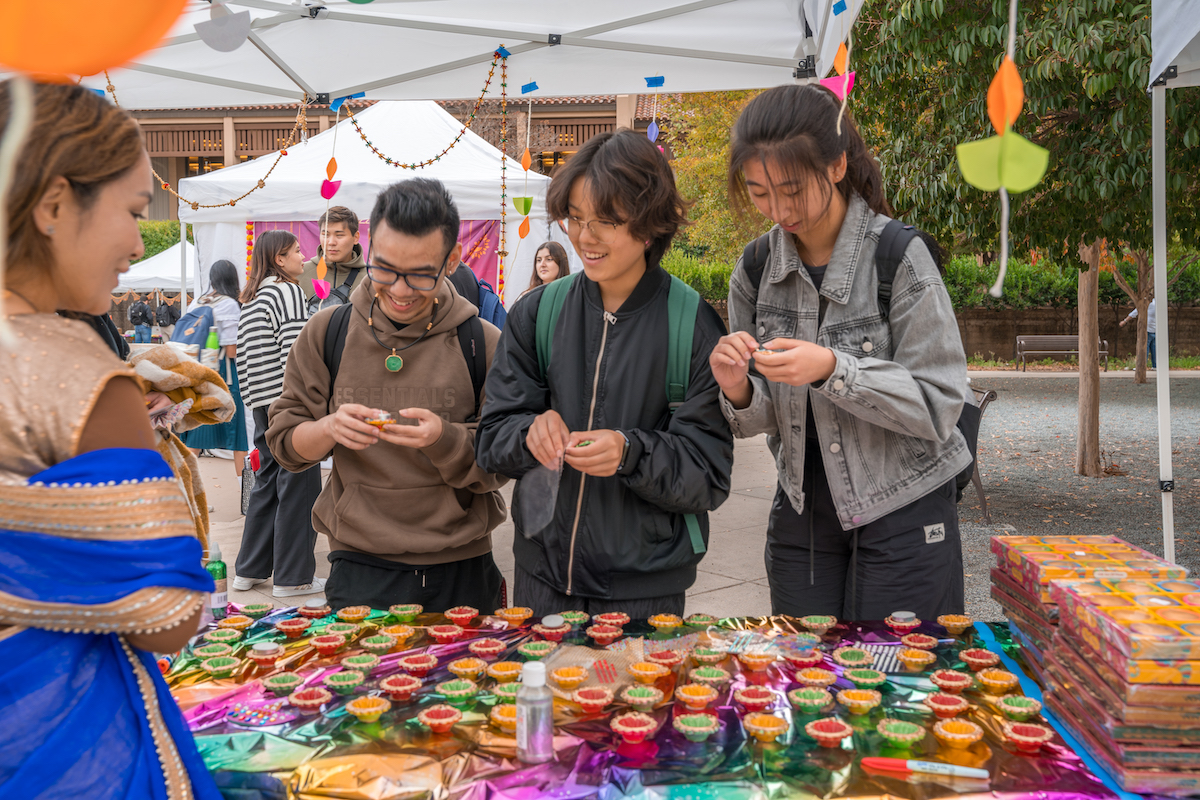 students at table with colorful candles and other items