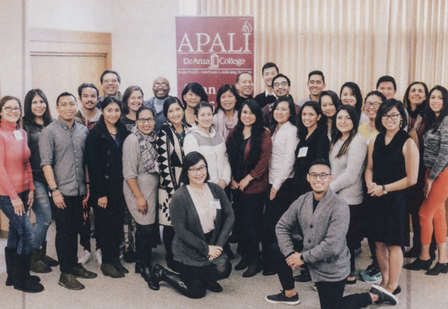 A diverse group of people gathered in front of a banner that reads "APALI / De Anza College" 