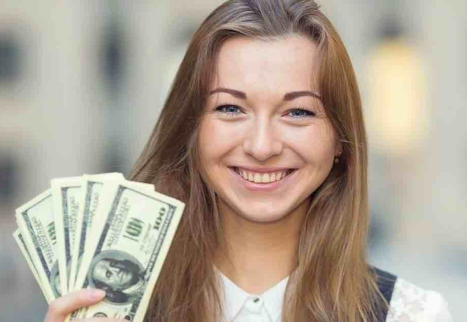 young woman holding up fanned money