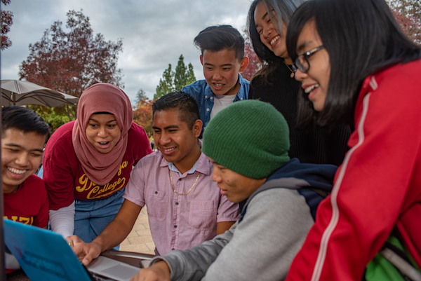 students exclaiming at something on laptop