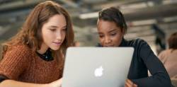 Two students working on a laptop