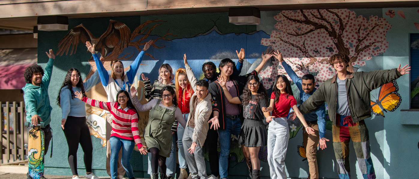 students in front of mural near campus center