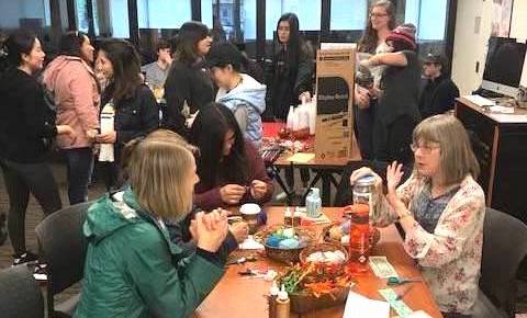 students talking around table and standing in crowded room