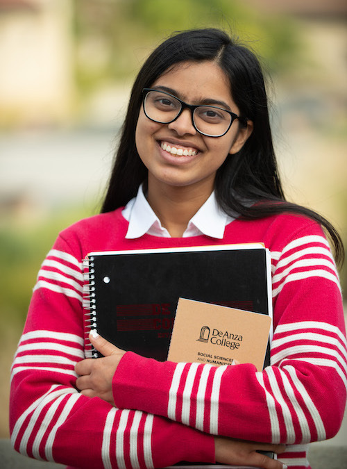 young woman with straight dark hair, glasses, college notebook