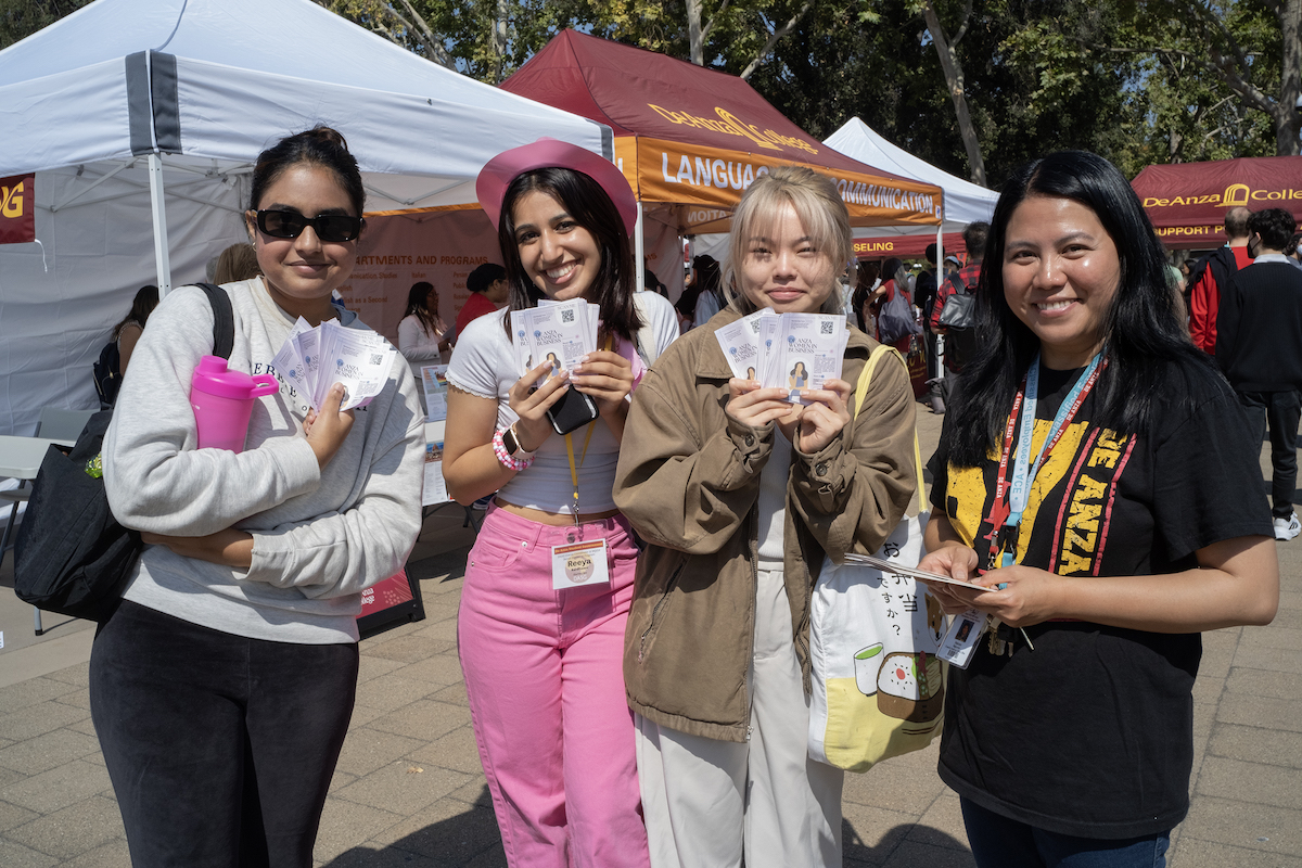 four young women holding up flyers